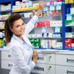 Beautiful smiling young woman pharmacist doing his work in pharm
